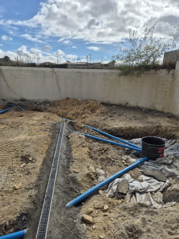 Accueil Réseaux d'eaux pluviales en cours de pose : tuyaux, regard et caniveau, travaux d'assainissement Porée TP